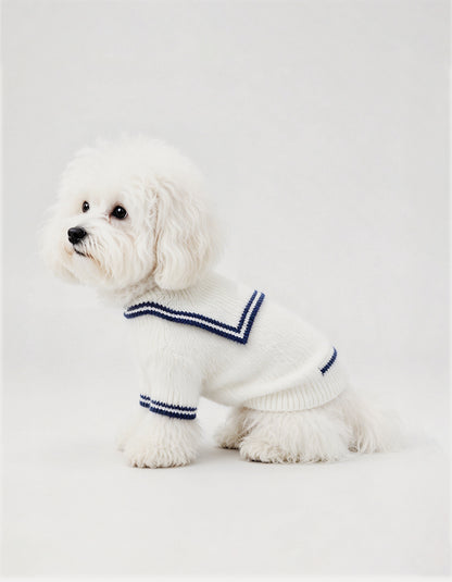 A fluffy white Coton de Tuléar dog wearing a white mink knit sailor cardigan by CHISUPET  for warm autumn and winter walks