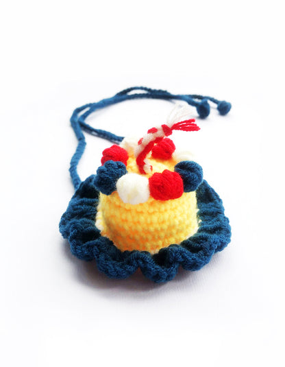 close-up of blue cake style pet birthday hat made of soft knitted yarn with layered frosting design