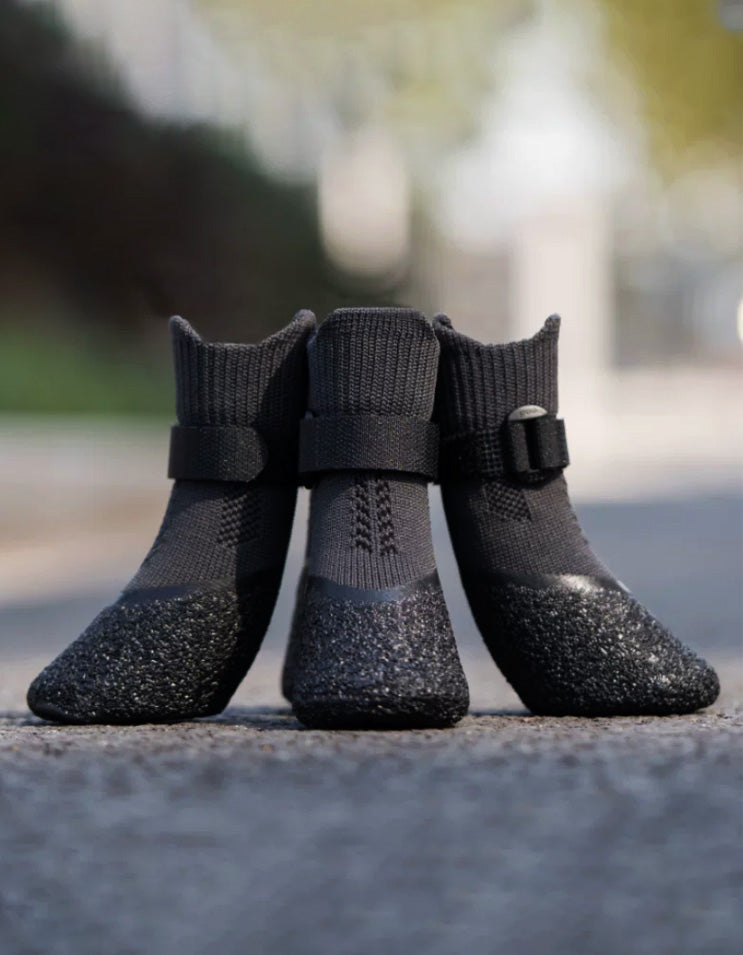 Close-up of black performance dog boots featuring segmented wrap-around straps